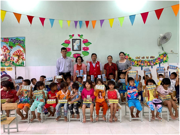 Đồng chí Lê Phong, Phó chủ tịch thường trực Hội chữ thập đỏ tỉnh trao sữa cho các em học sinh Trường mẫu giáo trên địa bàn huyện